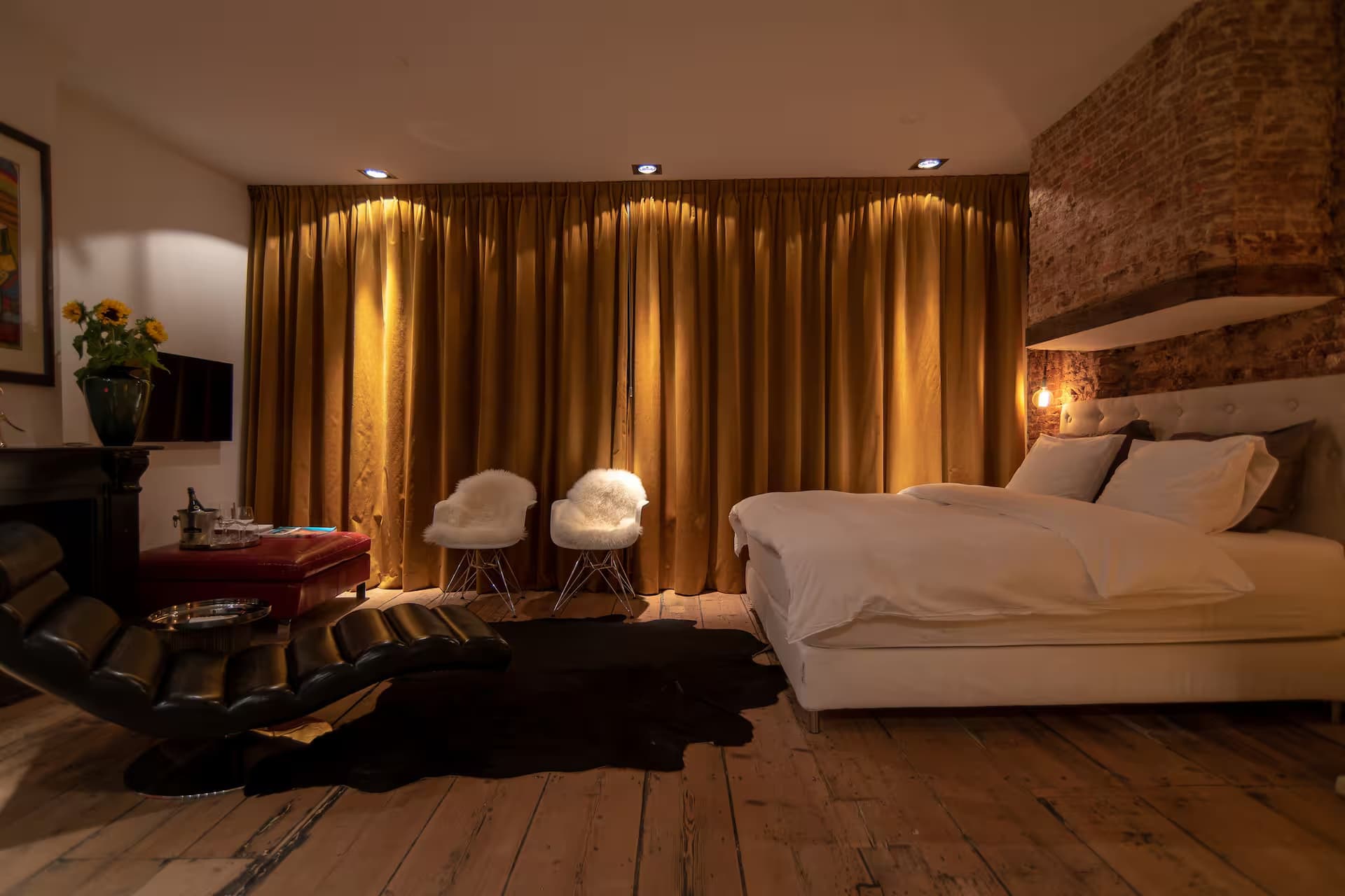 Double Fun — kameroverzicht in avondlicht met gouden velvet gordijnen, schaapsvacht-fauteuils en chaise longue