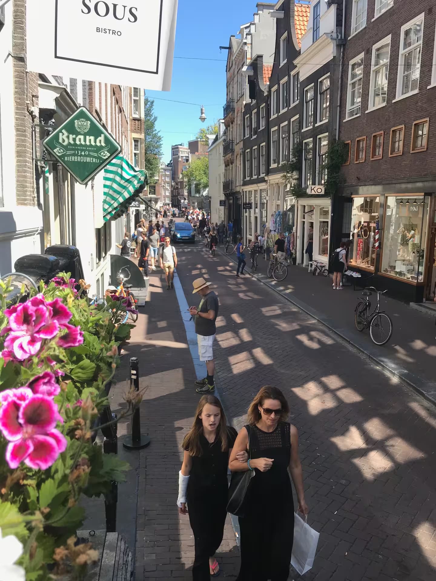 Double Fun — raam-uitzicht op de 9 Straatjes met Sous bistro en levendige zomerstraat